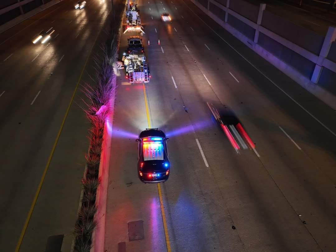 A Texas reserve peace officer in uniform standing beside a marked patrol vehicle